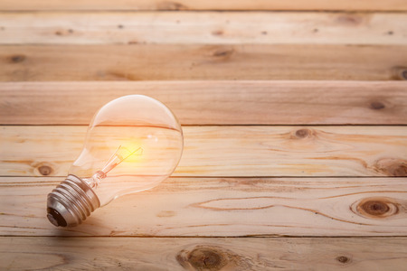 light bulb with brown wooden floor background Business ideas conceptの写真素材