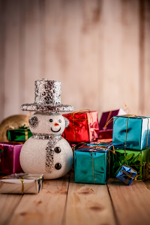 Christmas background with snowman on a rustic wooden boardの写真素材