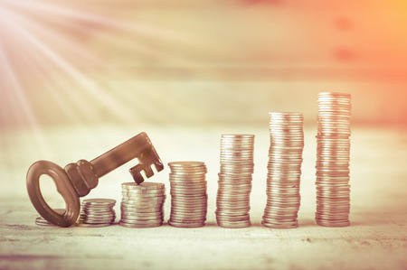 coin stack and red color key on wooden bacground. business conceptの写真素材