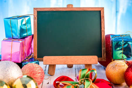 Merry Christmas decorations, chalkboard with free copyspace and gifts decorate on a timber backgroundの写真素材