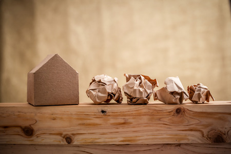 model of paper house building with trash paper balls, loan, real estate or buying a new home concept.with copy spaceの写真素材