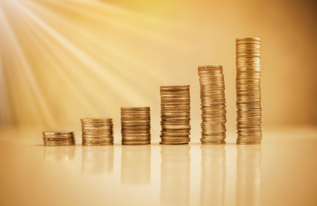 stack of coins on white floor againt with blur bokeh background business conceptの写真素材