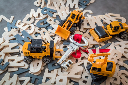 success process with truck toys and silver key on grey leather backgroundの写真素材