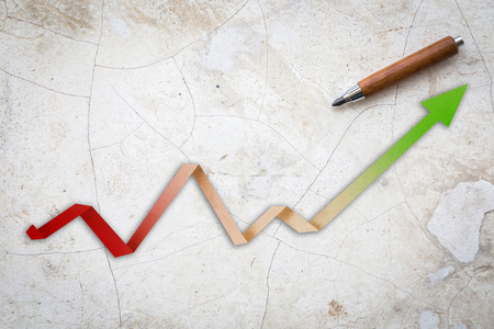 Economic Arrow With Growing Trend arrow paper cut with wooden pencil on blue leather backgroundの写真素材