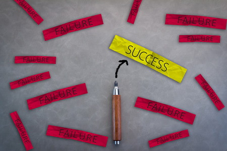 BUSINESS SUCCESS CONCEPT WITH SUCCESS AND FAILURE ON A PAPER NOTE WITH WOODEN PENCIL ON GREY LEATHER BACKGROUND AND FREE COPY SPACE FOR YOUR CREATIVITY IDEAS CONCEPTの写真素材