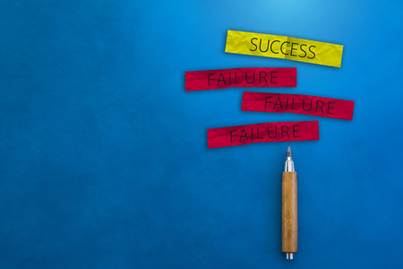 BUSINESS SUCCESS CONCEPT WITH SUCCESS AND FAILURE ON A PAPER NOTE WITH WOODEN PENCIL ON COLOR  LEATHER BACKGROUND AND FREE COPY SPACE FOR YOUR CREATIVITY IDEAS CONCEPTの写真素材