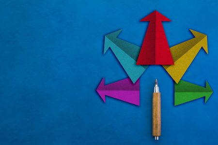 solution ideas concept with colorful arrow paper shape with wooden pencil and free copy space on blue leather backgroundの写真素材