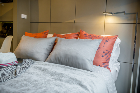 Bed maid-up with clean white pillows and bed sheets in beauty room. Close-up. Lens flair in sunlight.の写真素材