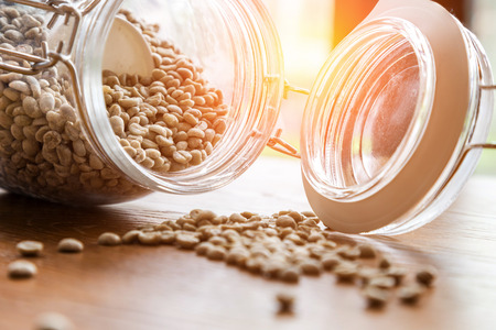 roasted coffee beans,Coffee beans in glass jar on wooden background.