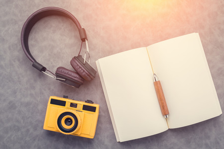 Set of travel stuff. Camera, headphones, notepad  on grey table. Top view with copy spaceの写真素材