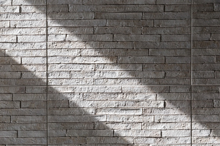brick wall light color texture with direct light area from sunlight near windowの写真素材