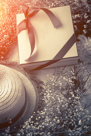 Spring flowers narcissus and box with present on white painted wooden planks. Selective focus. Place for text.の写真素材