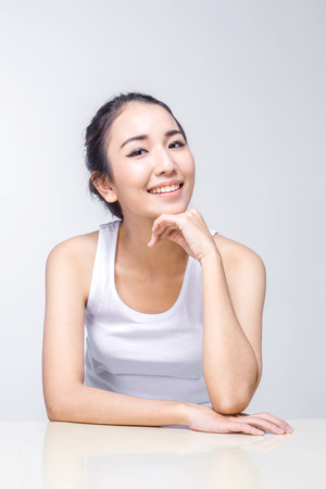 Beautiful woman cares for the skin face - posing at studio isolated on white backgroundの写真素材