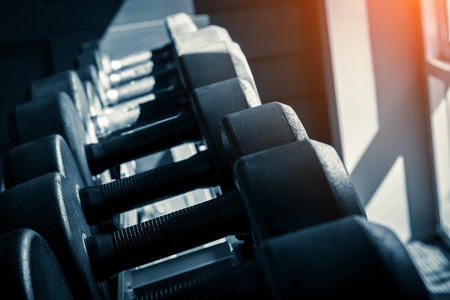 Rows of dumbbells in the gym with hign contrast and monochrome color tone