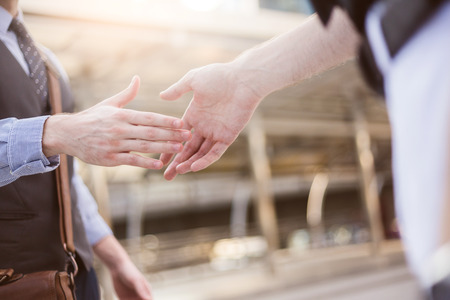 Business handshake. Business handshake and business people concept. Two men shaking hands over sunny office background. Partnership, Dealの写真素材