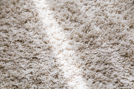 beige color domestic carpet texture with light spot from window curtainの写真素材