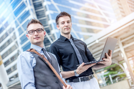 smart business man brainstorm with laptop outside office with urban city building backgroundの写真素材