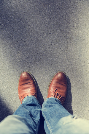 man brown leather shoe with blue jeans on street road with free copyspaceの写真素材