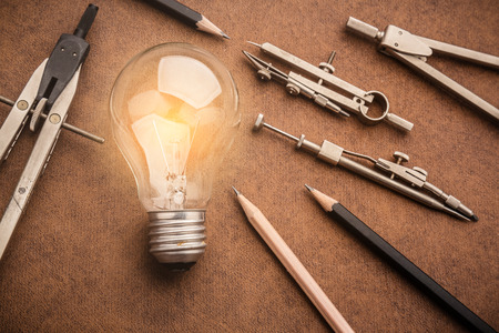 drawing tool with glow light bulb on leather background creativity  ideas conceptの写真素材