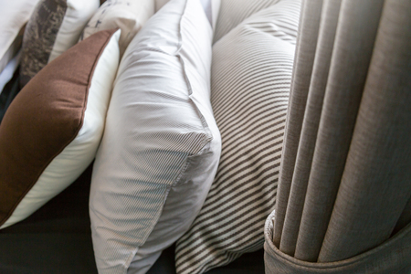 Bed maid-up with clean white pillows and bed sheets in beauty room. Close-up. Lens flair in...