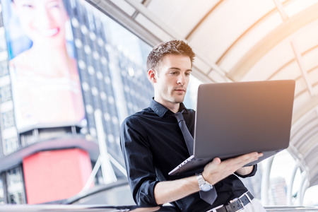 Caucasian businessman use of the notebook computer at outdoorの写真素材