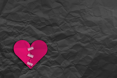 heart broke with tape fix and Crumpled fold white paper sheet background love problem conceptの写真素材