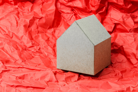 house model cardboard paper on red crumpled paper backgroundの写真素材