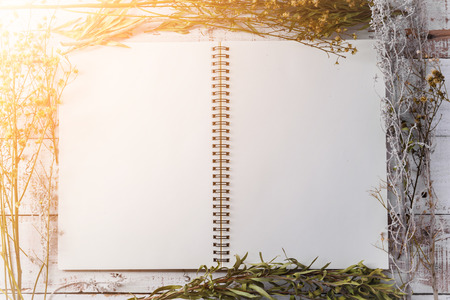 blank notebook on old vintage with dry flower on wooden background with free copyspace for your textの写真素材