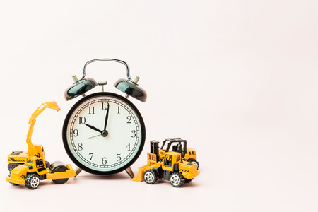 time concept with black alarmclock and consruction toy car with free copyspace for your text