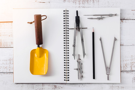 house deisgn concept with drawing tool on notebook and vintage wood background