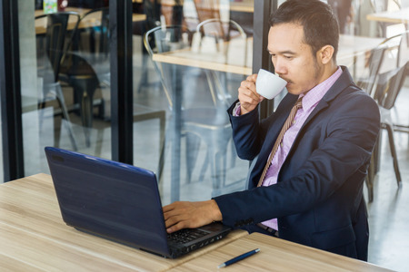 asian business man working with laptop in cafe backgroundの写真素材