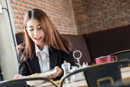 beautiful asian gril surprise with her food  in restaurantの写真素材