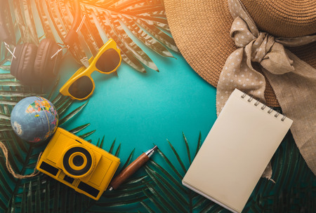 summer concept with travel stuff camera notebook glasses and woman hat flatlay image on color background with free copy spaceの写真素材