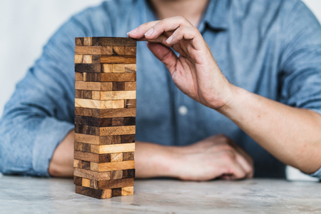 hand pull important color block from balance wooden stack business organize  strategy and risk...