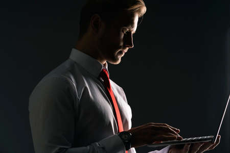 smart caucasian businessman red neck tie white shirt hand hold laptop with thinking and concentrate with  strategy and creativity business ideas conceptの写真素材