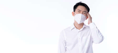 close up young asian male businessman wearing pollution mask with gesture action express ill sickness bad health from weather with pm2.5 environment city air problemの写真素材