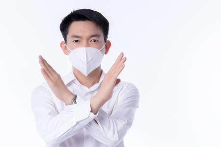 close up young asian male businessman wearing pollution mask with gesture action hand cross to say...