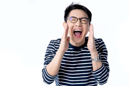 smart attractive asian glasses male hand rise up cheerful exited standing and smile with freshness and joyful casual blue shirt portrait white backgroundの写真素材