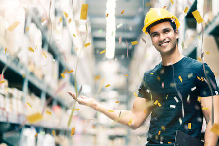 Smart Indian engineer man wearing safety helmet doing stock tick check and cardboard stock product...