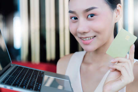 successful online shopping with beautiful asian woman hand present laptop and credit card with...