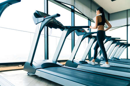 beautiful asian healthy sport woman workout run on treadmill in gym