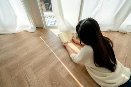 happiness and peaceful asian woman enjoy melody and book weekend house background