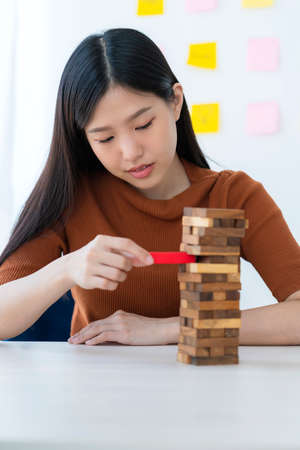 business creativity and strategy ideas concept smart beautiful asian woman try to built wooden block tower to stable and successful white backgroundの写真素材