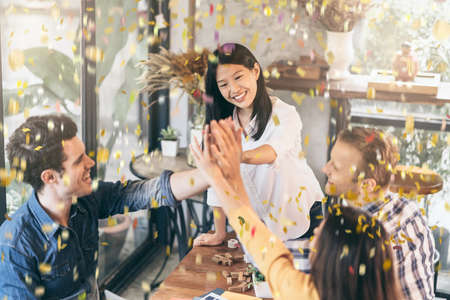 success victory creative meeting with multination coworker partners with hand power and confetti papershoot with happiness and joyfulの写真素材