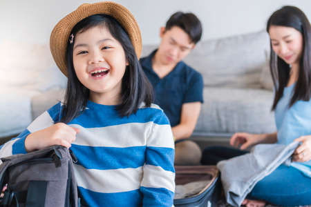 Asian Family travel concept happiness dad mom daughter packing stuff and planing for vacation trip...