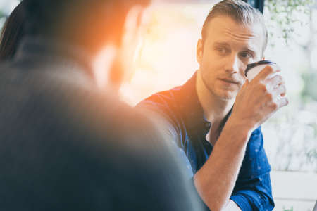 two smart caucasian man meeting and consult with serious and focusing conversation near window cafe...