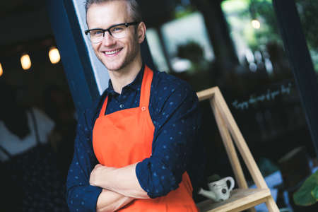 Portrait of happy young man wearing an apron attractive caucasian Male Barista cafe restaurant owner...