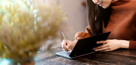 banner header attrative smile asian woman enjoy weekend with writing diary in cafe with light flare image color toneの写真素材