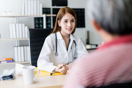 smart and attractive asian woman doctor explain and discuss with old asian man for consult clinic...