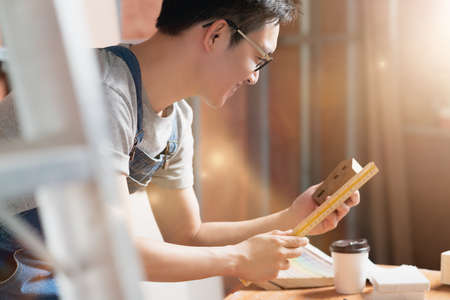 asian attractive glasses interior designer working at house site renovation construction progress...